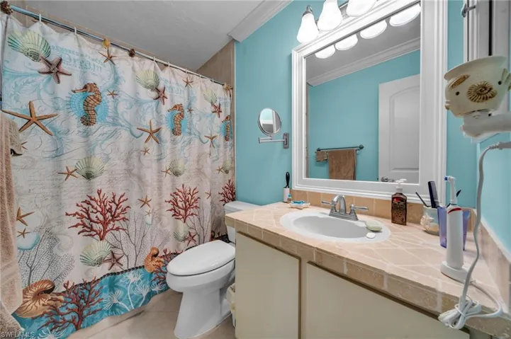 Bathroom with vanity, a shower with curtain, crown molding, toilet, and tile patterned floors