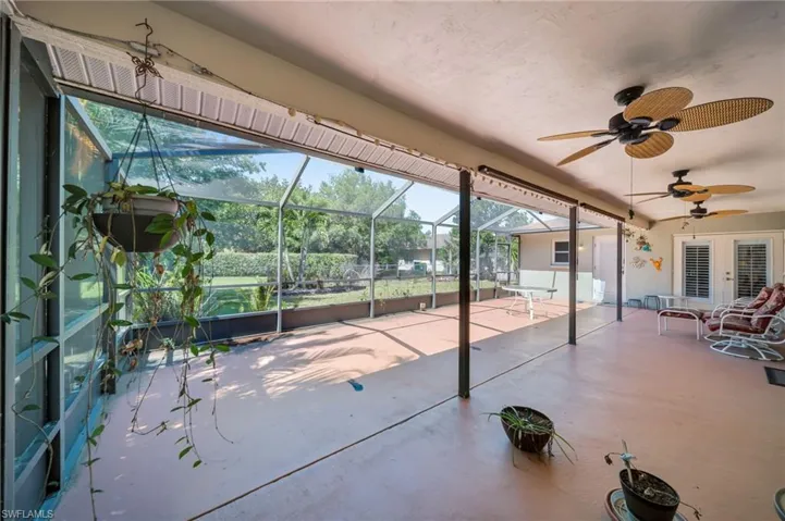 View of patio / terrace featuring glass enclosure, french doors, and ceiling fan