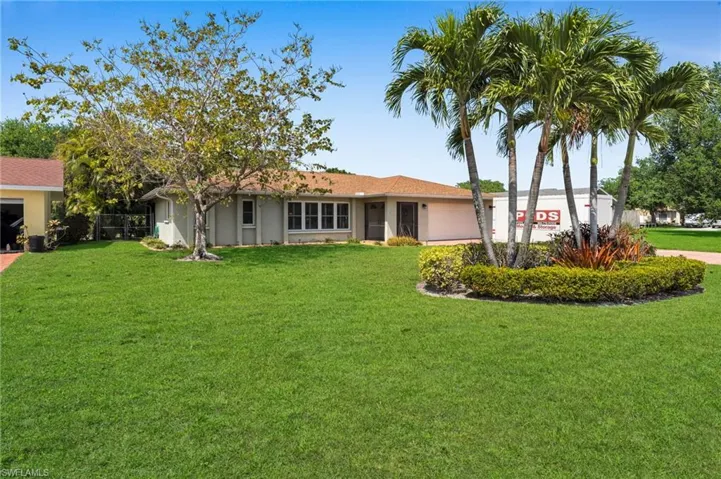View of front of home with stucco siding and a front lawn