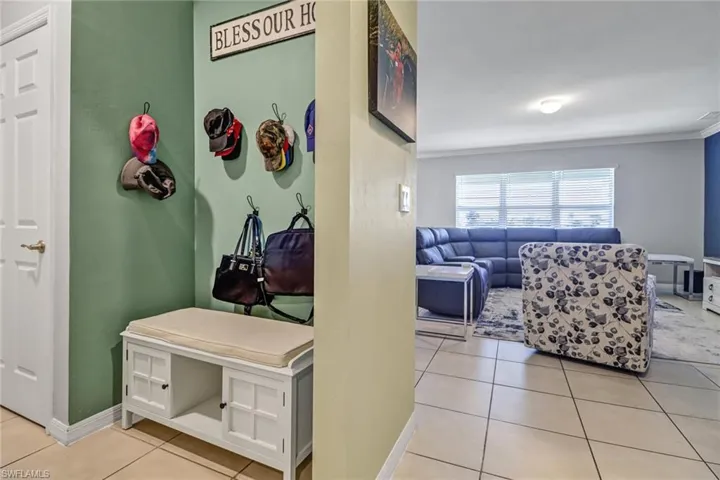 Mudroom featuring ornamental molding and light tile patterned floors