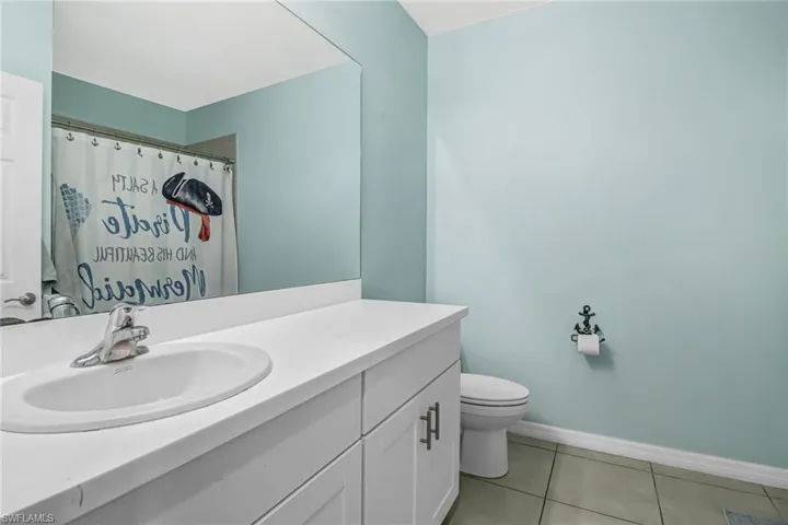 Bathroom featuring toilet, vanity, and tile patterned flooring