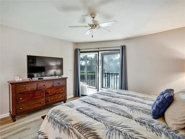 Bedroom featuring access to outside, light wood-style flooring, and ceiling fan