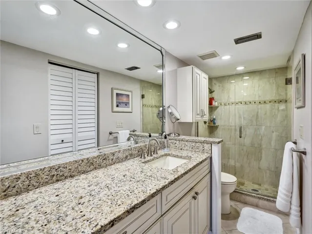 Full bath with a stall shower, vanity, recessed lighting, a closet, and light tile patterned floors