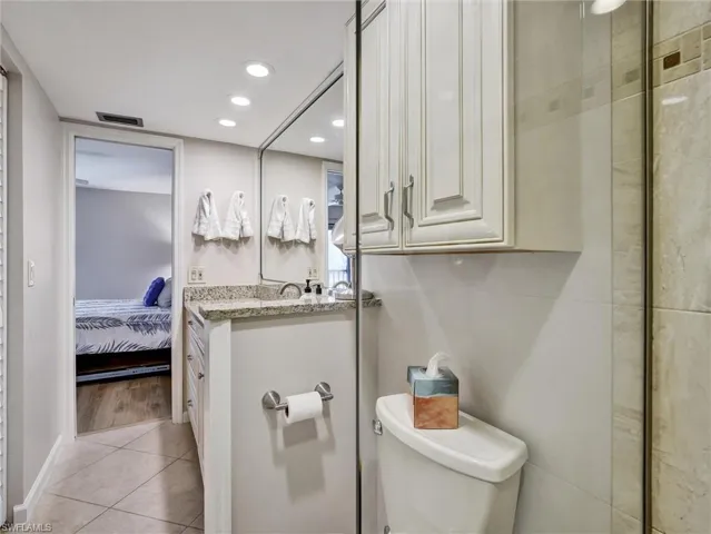 Ensuite bathroom featuring recessed lighting, vanity, and light tile patterned flooring