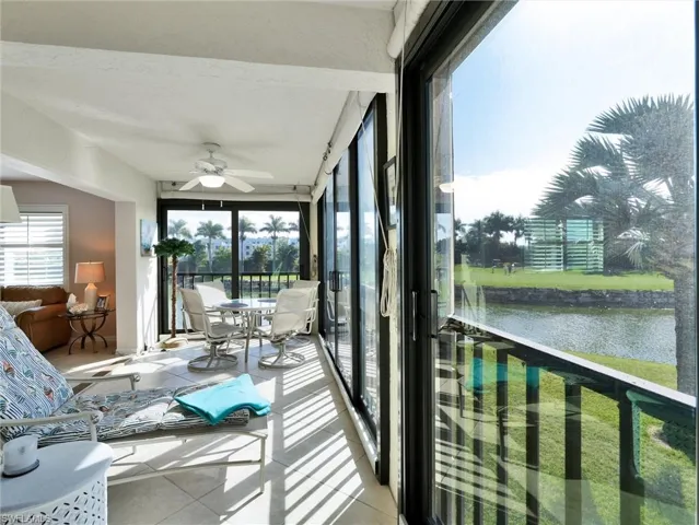 Sunroom / solarium featuring tile patterned floors and a water view