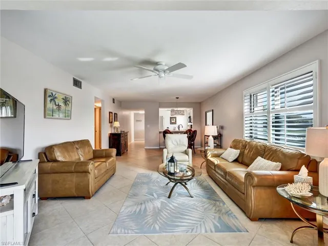 Living area with ceiling fan and light tile patterned floors