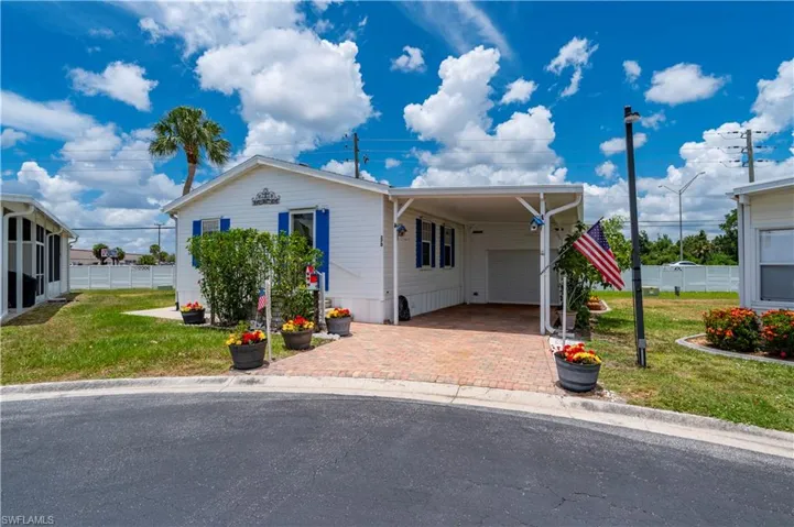 Manufactured / mobile home with a front lawn and a carport