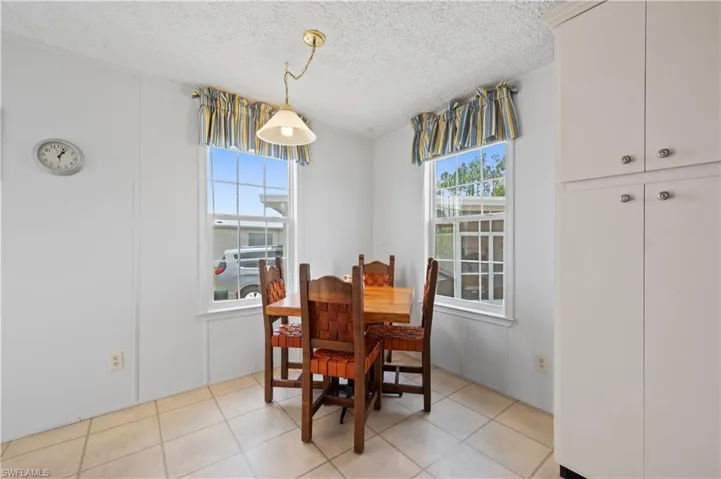 Dining space with a textured ceiling and light tile floors