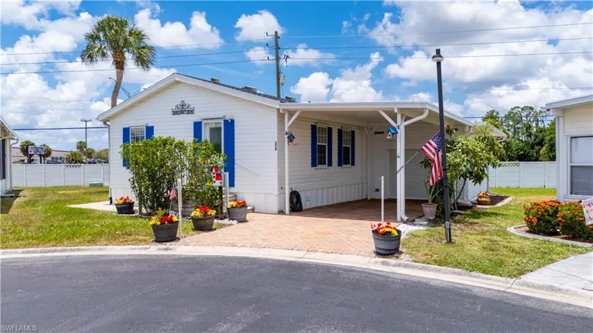 View of front facade featuring a front yard and a carport