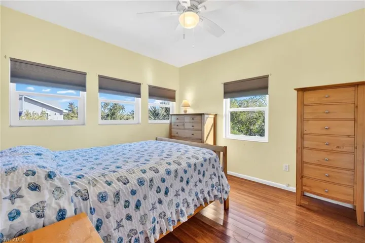 Bedroom with hardwood / wood-style floors and a ceiling fan