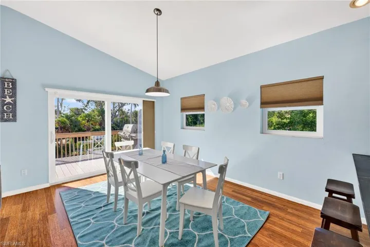 Dining space with healthy amount of natural light, dark wood-type flooring, and high vaulted ceiling
