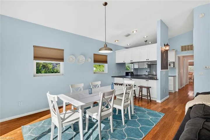 Dining space with dark wood-type flooring and recessed lighting