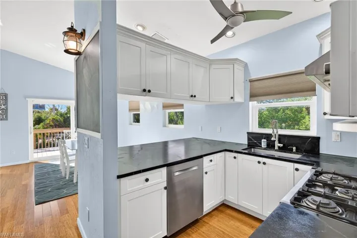 Kitchen featuring dishwasher, healthy amount of natural light, ceiling fan, gas cooktop, and lofted ceiling
