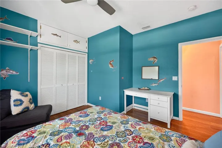 Bedroom featuring dark wood finished floors, a ceiling fan, and a closet