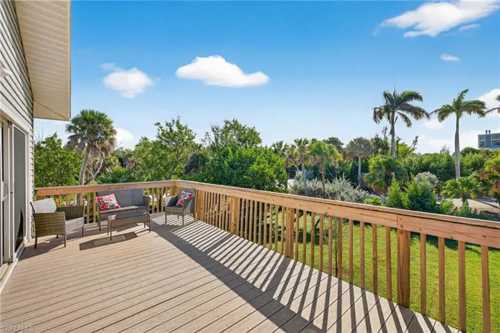 Wooden terrace featuring an outdoor hangout area and a lawn