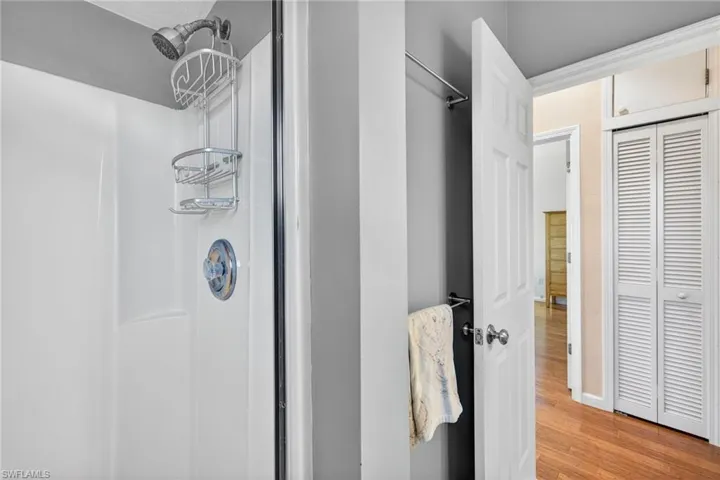 Full bathroom with a stall shower and wood finished floors