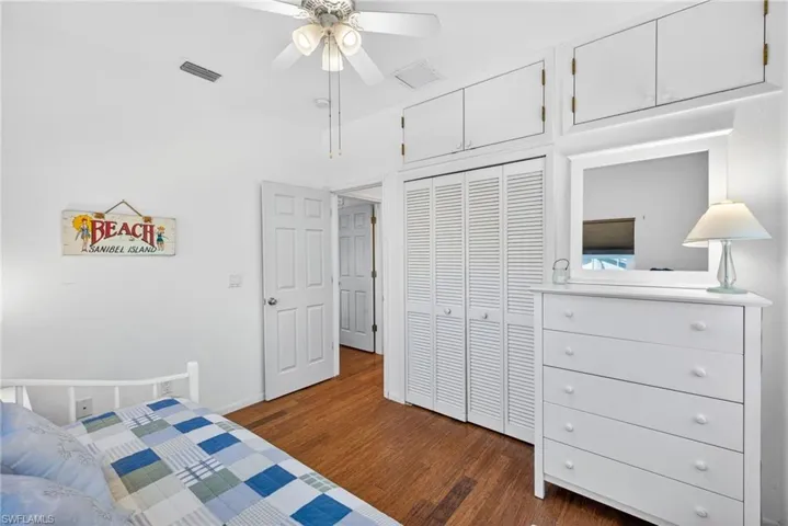 Bedroom with dark wood finished floors, a ceiling fan, and a closet