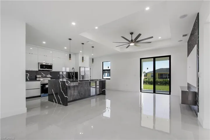 Living room featuring visible vents, a ceiling fan, recessed lighting, baseboards, and a raised ceiling
