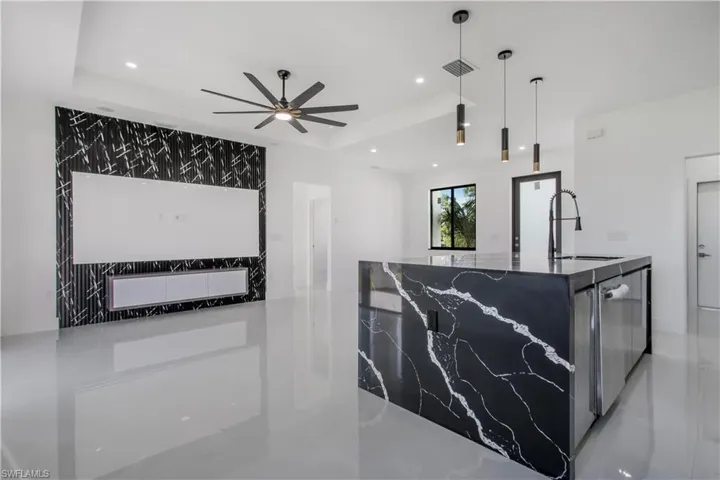 Kitchen with visible vents, an island with sink, a tray ceiling, recessed lighting, and a ceiling fan