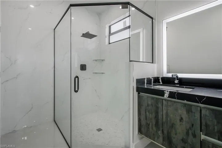 Full bathroom with a marble finish shower and vanity