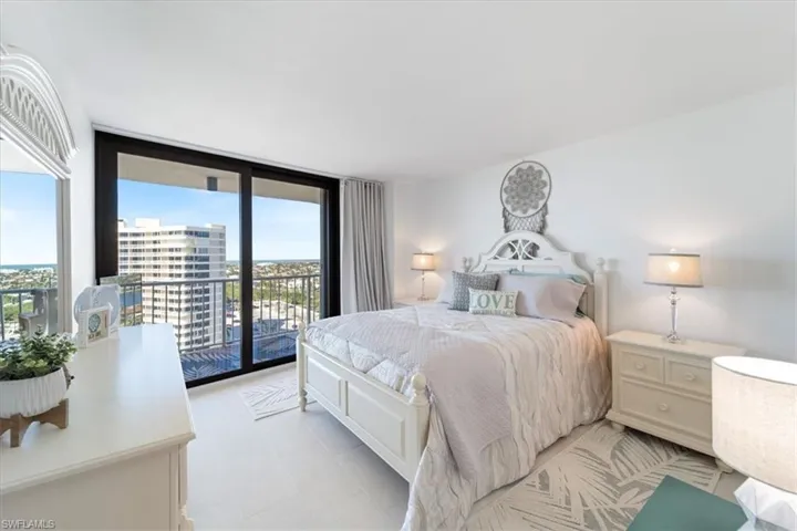 Bedroom with a wall of windows and access to outside