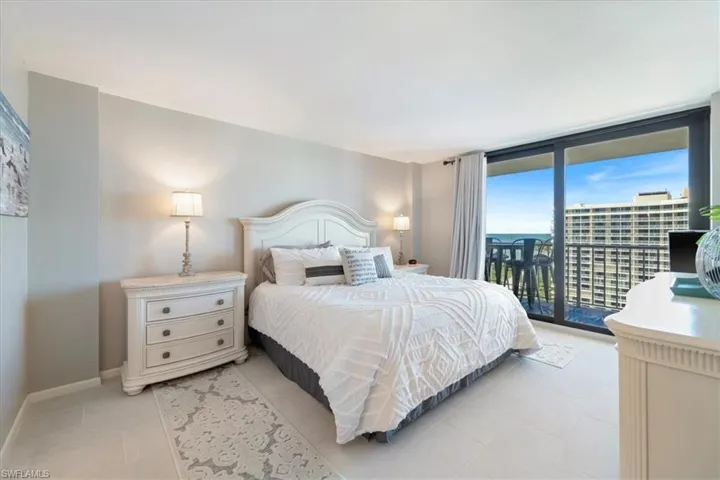 Bedroom with expansive windows, access to exterior, and light tile patterned flooring