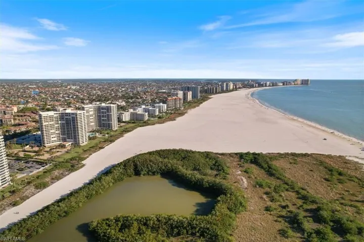 Aerial view featuring a water view and a beach view