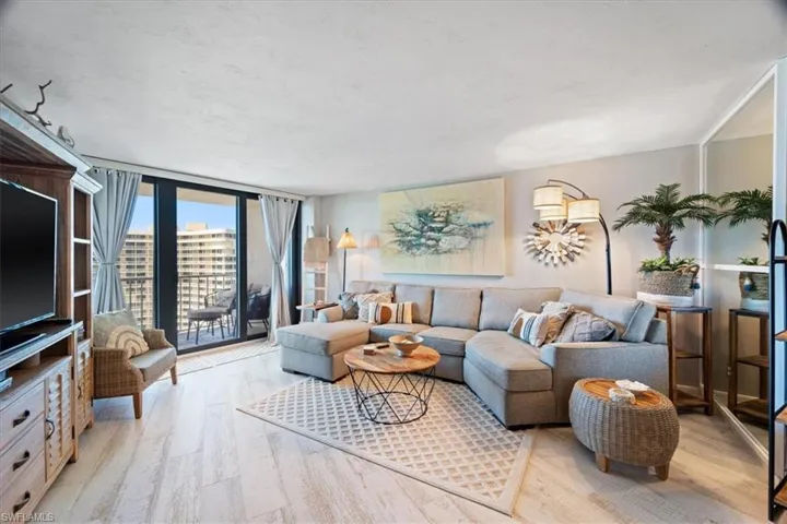 Living room with floor to ceiling windows and light hardwood / wood-style flooring
