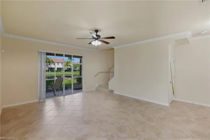 Unfurnished room featuring a ceiling fan, ornamental molding, and light tile patterned floors