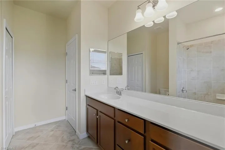 Bathroom featuring vanity, a closet, and light tile patterned floors