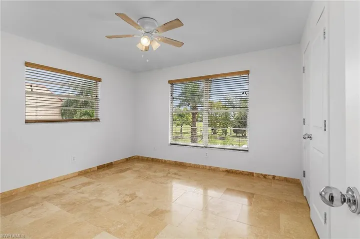Unfurnished room featuring plenty of natural light, ceiling fan, and light tile floors