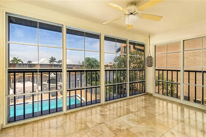 Unfurnished sunroom featuring ceiling fan