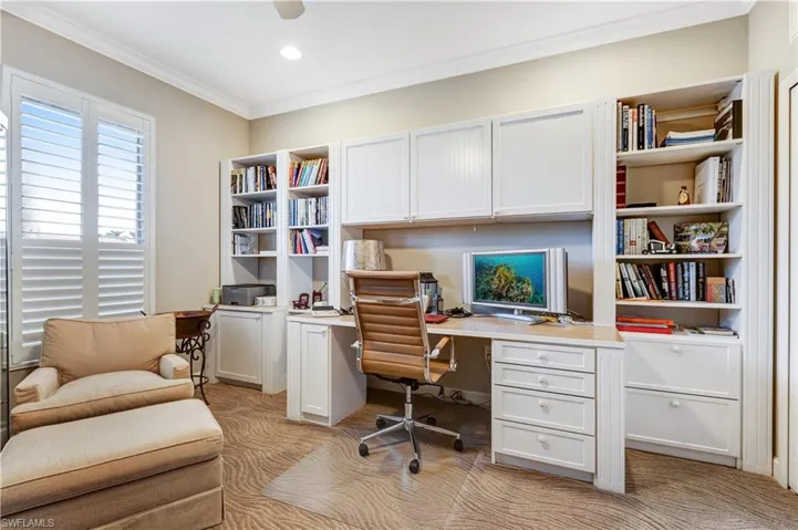 4th bedroom utilized as an office with beautiful plantation shutters and a built in desk with lots of storage