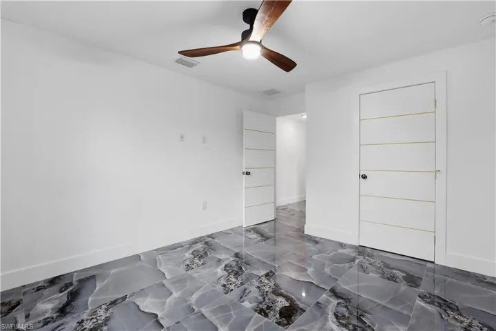 Unfurnished bedroom with ceiling fan and baseboards