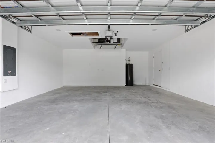 Garage featuring electric panel and water heater