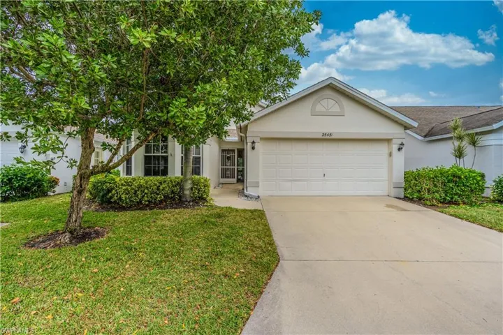 Ranch-style house featuring stucco siding, concrete driveway, a front lawn, and an attached two car garage