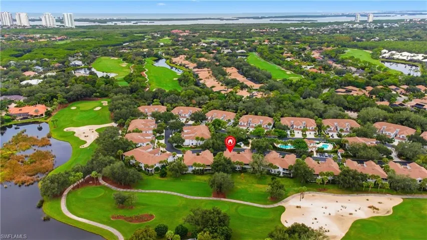 Aerial view of residential area featuring a golf club and a large body of water