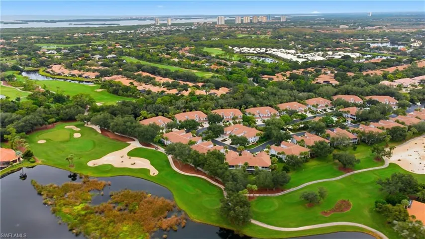 Aerial perspective of suburban area featuring a nearby body of water and a local golf course
