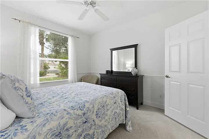 Bedroom with ceiling fan and light tile patterned floors