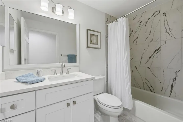 Bathroom featuring vanity and shower / bath combo with shower curtain