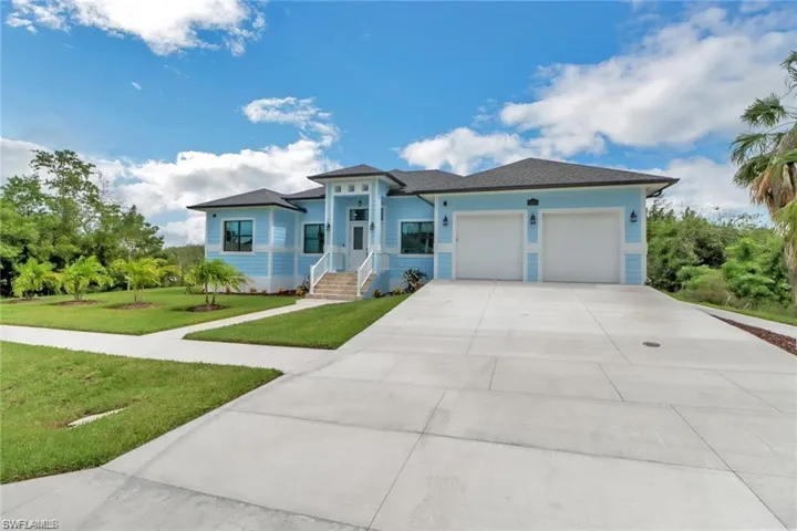 View of front of property featuring covered porch, a front yard, and a garage