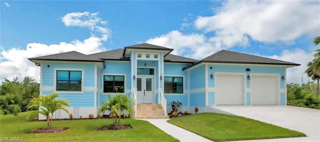 View of front of property featuring a front yard and a garage