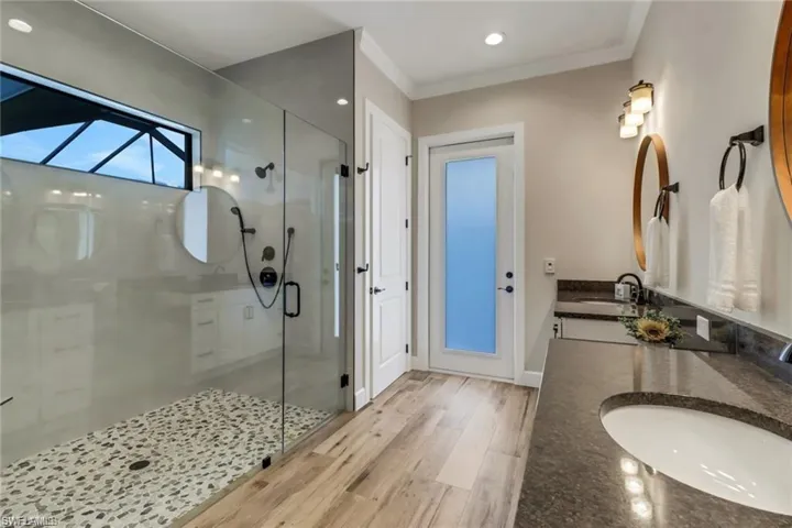 Bathroom with wood-type flooring, vanity, an enclosed shower, and crown molding