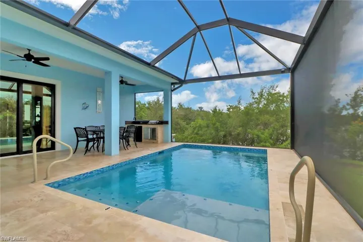 View of swimming pool with a lanai, ceiling fan, and a patio area