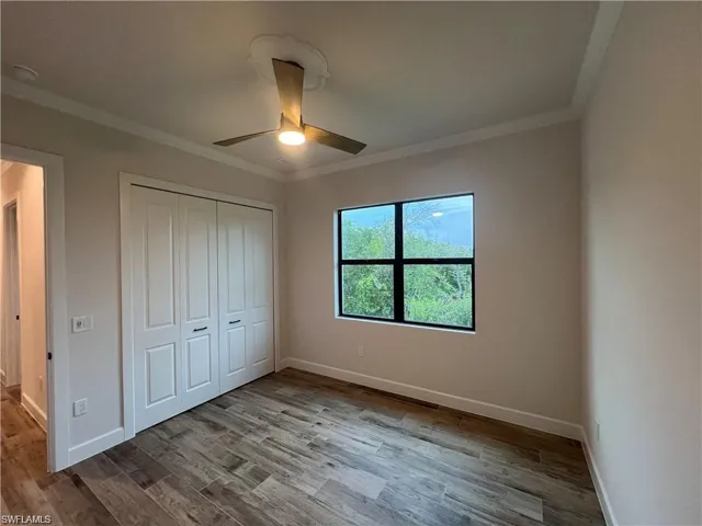 Unfurnished bedroom with light hardwood / wood-style flooring, a closet, ceiling fan, and crown molding
