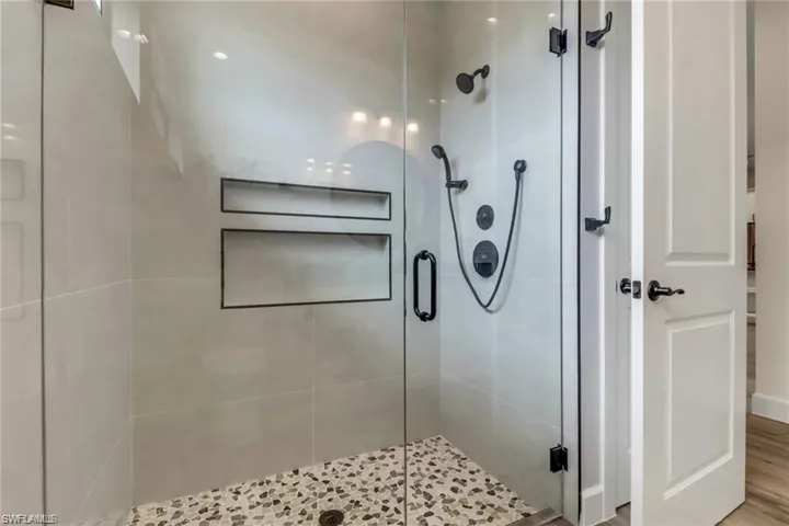 Bathroom featuring hardwood / wood-style floors and a shower with shower door