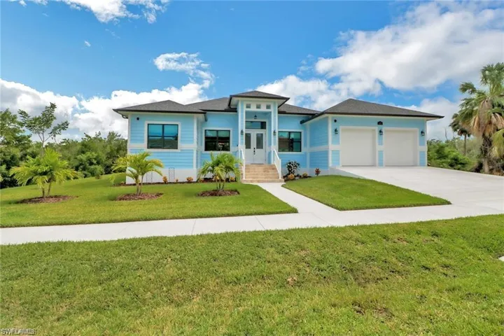View of front facade with a garage and a front lawn