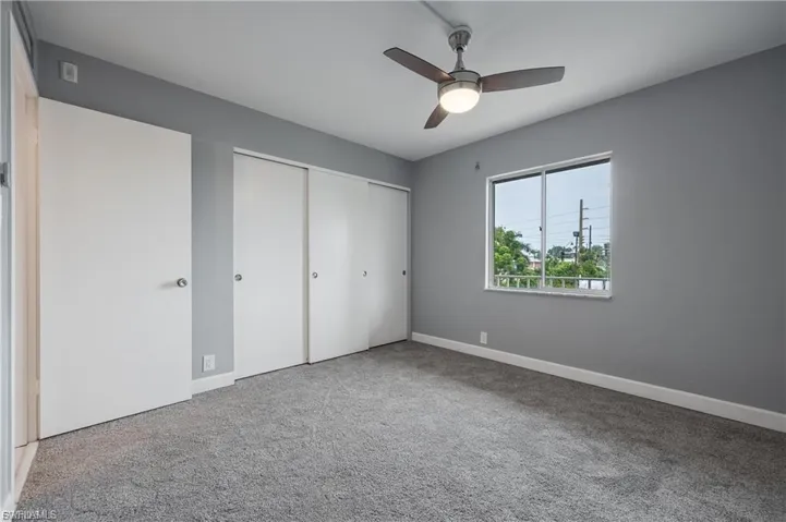 Unfurnished bedroom featuring a closet, light carpet, and a ceiling fan