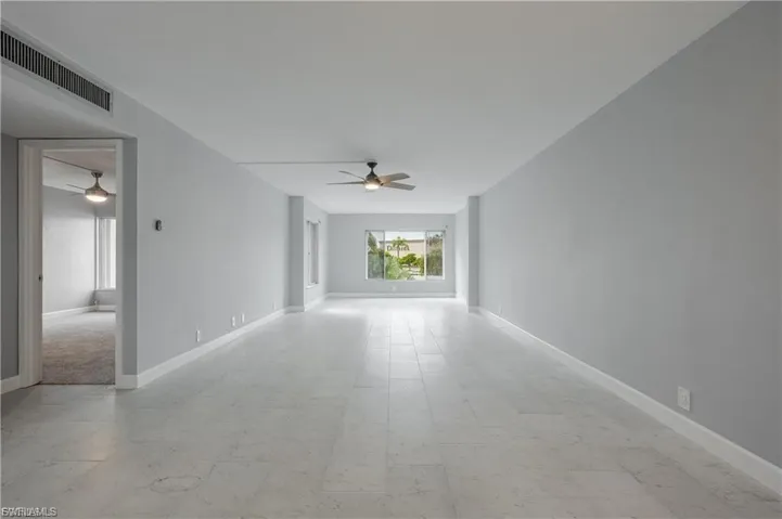 Empty room with light flooring and ceiling fan