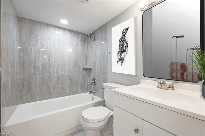 Bathroom with vanity, bathtub / shower combination, and recessed lighting